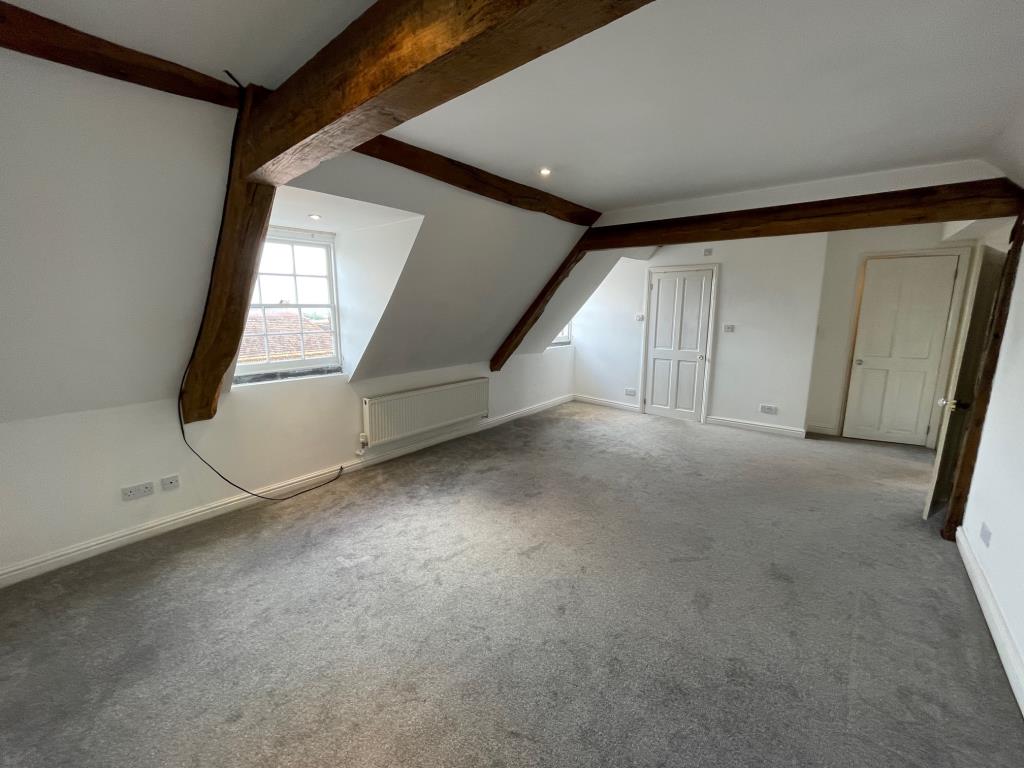 Lot: 90 - VACANT TOP FLOOR FLAT WITH VIEWS OVER SURROUNDING AREA - living room with exposed beams and door to bathroom